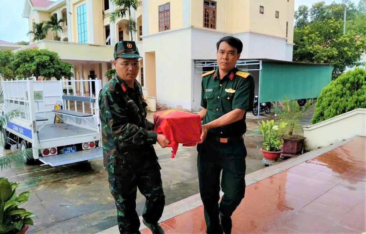 Lực lượng chức năng đưa hài cốt liệt sĩ đi an táng. Ảnh: QS.