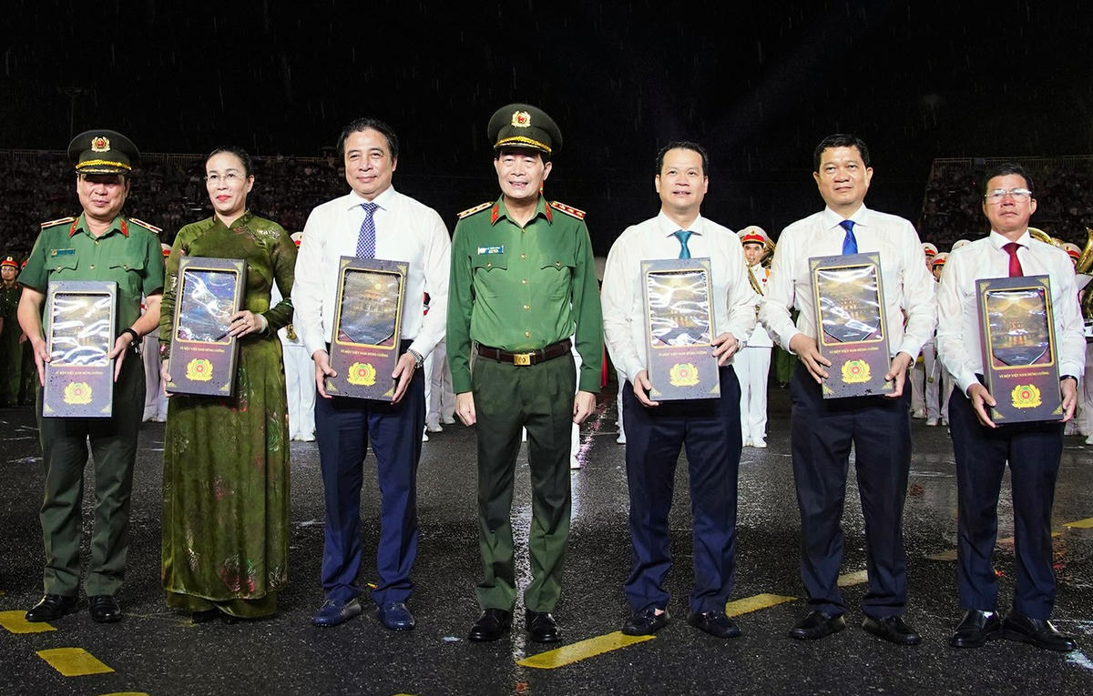 Thượng tướng Lê Quốc Hùng (ở giữa), tặng quà lưu niệm của Bộ trưởng Bộ Công an cho đại biểu lãnh đạo thành phố. Ảnh: CĐ.