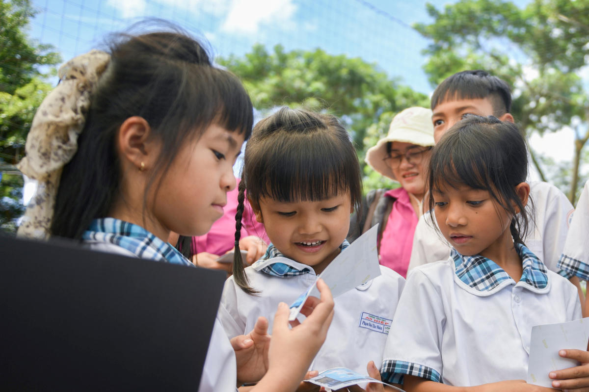 Các em học sinh hào hứng viết ước mơ, chụp ảnh và chờ khoảnh khắc nhìn thấy mình trong trang phục nghề nghiệp mơ ước (Ảnh: Hải An).