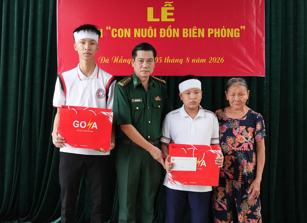Đại tá Hoàng Văn Mẫn, Chính ủy BĐBP TP Đà Nẵng tặng quà cho hai anh em Lê Viết Hồng Anh và Lê Viết Hồng Pháp. Ảnh: BP.