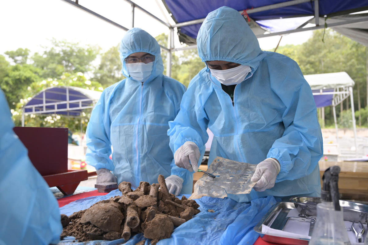 Lực lượng chức năng phát hiện di vật mang thông tin liệt sĩ trong quá trình lấy mẫu ADN tại Nghĩa trang Liệt sĩ Tri Tôn, An Giang. Ảnh: Phương Vũ