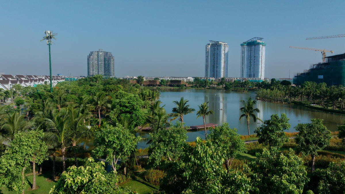 A body of water with trees and buildings in the background

Description automatically generated