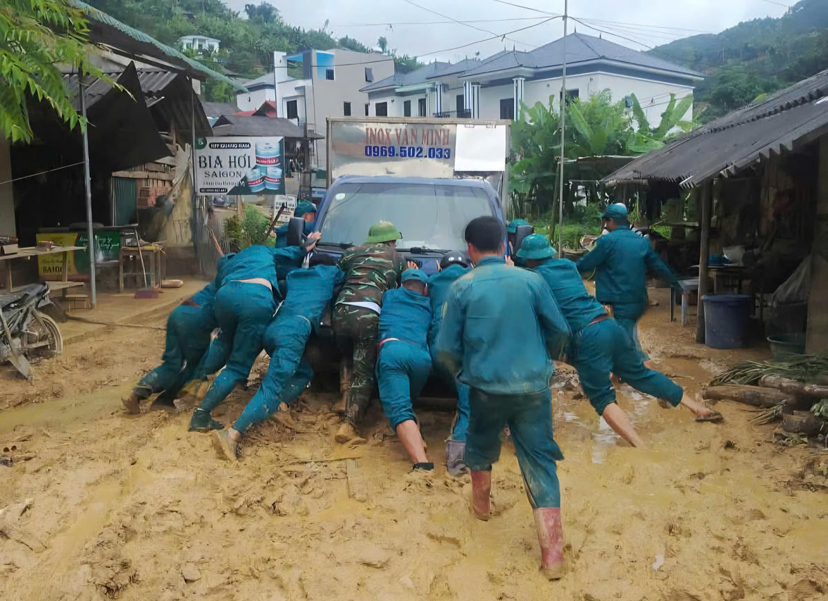 Lực lượng chức năng hỗ trợ người dân ứng phó với mưa lũ. Ảnh: H.H