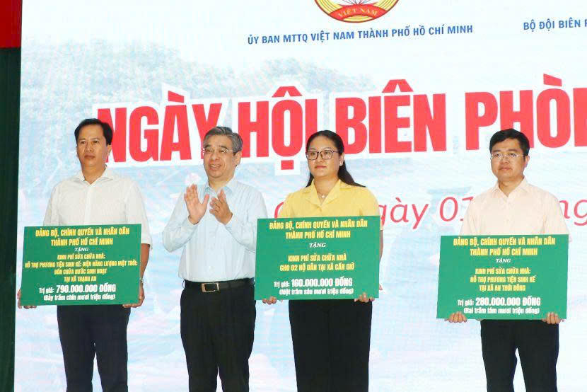 Lãnh đạo TP Hồ Chí Minh trao bảng tượng trưng kinh phí xây dựng, sửa chữa nhà Đại đoàn kết trong chương trình “Ngày hội Biên phòng toàn dân” tại xã Cần Giờ. Ảnh: MTTP.