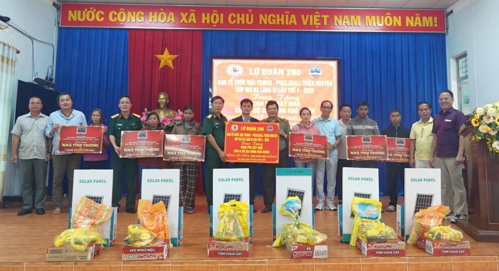 Ban tổ chức trao biển tượng trưng nhà Đại đoàn kết cho các hộ dân có hoàn cảnh khó khăn ở xã Kon Giang. Ảnh: ĐS.