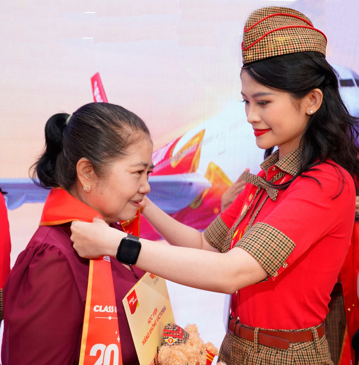 Nguyễn Lê Anh Thư tự hào đeo ruy băng tốt nghiệp cho mẹ.