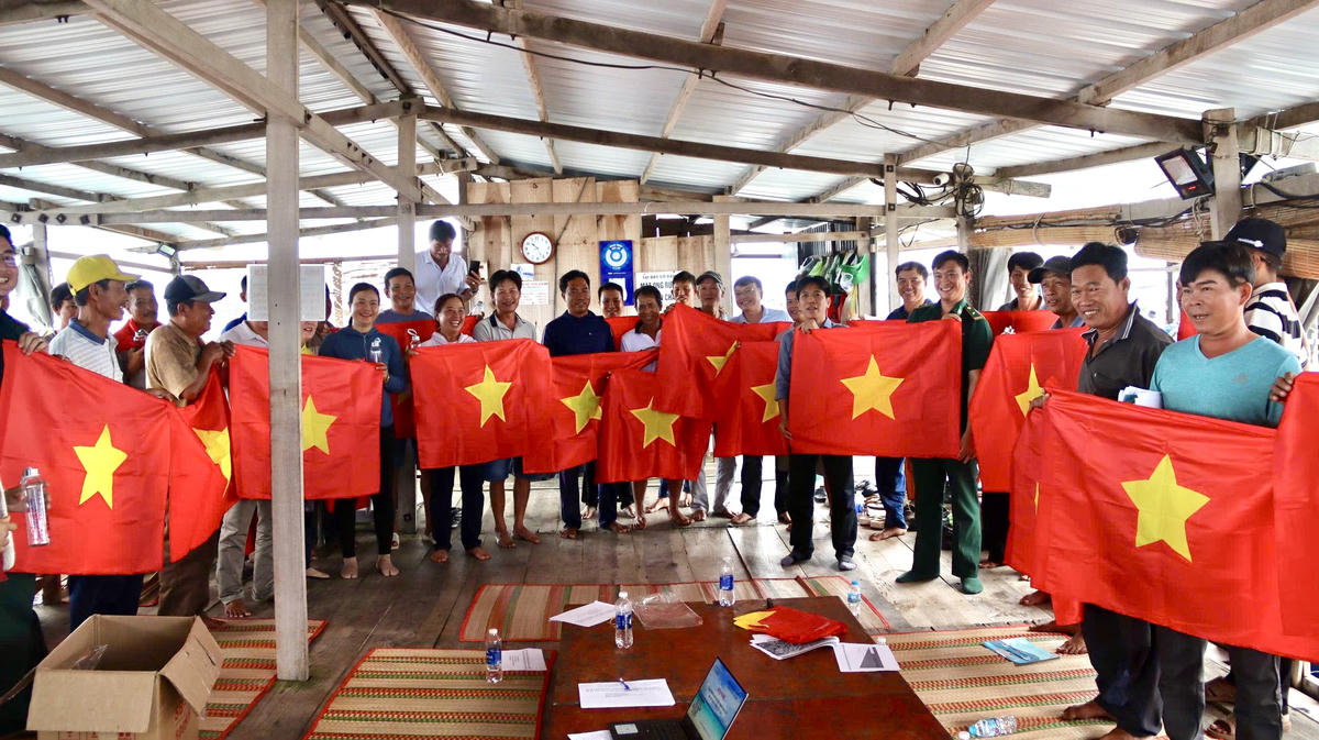 Đồn Biên phòng Long Sơn đã trao tặng 50 lá cờ Tổ quốc cho các hộ nuôi trồng thủy sản lồng bè trên địa bàn xã Long Sơn. Ảnh: Quang Tiến.
