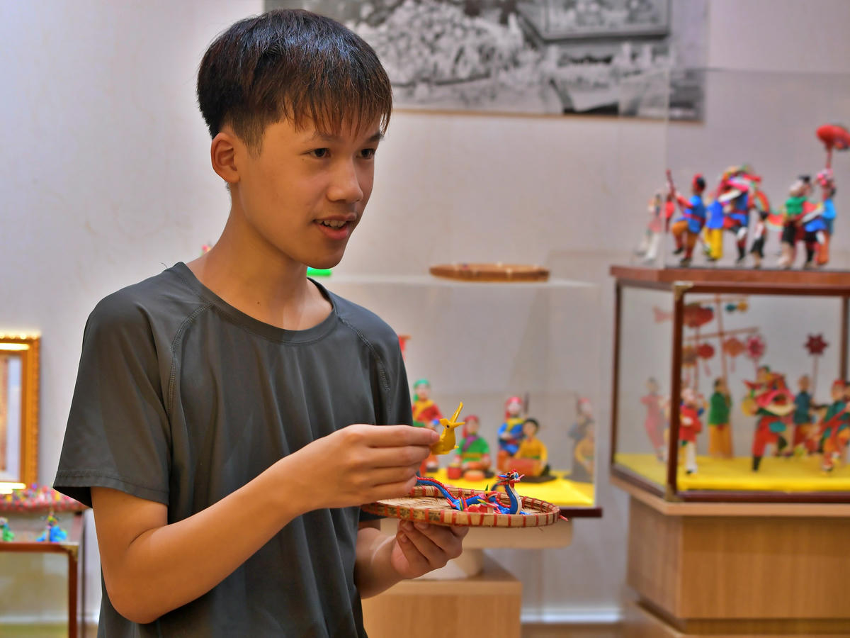 Con trai nghệ nhân Đặng Văn Hậu giới thiệu về sản phẩm tò he do chính tay mình tạo ra.