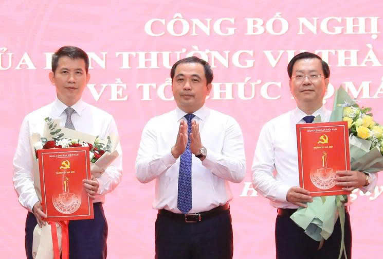 Bí thư Thành ủy Hà Nội Trần Đức Thắng trao quyết định và tặng hoa chúc mừng tân Giám đốc Sở Xây dựng Hà Nội Võ Nguyên Phong và Giám đốc Sở Văn hóa, Thể thao và Du lịch Hà Nội Phạm Tuấn Long (ngoài cùng bên trái). Ảnh: QT