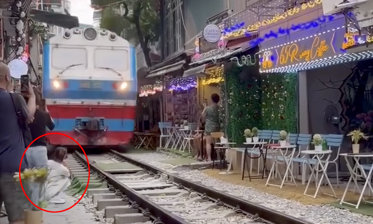 Chiếc điện thoại của cô gái bị đoàn tàu hất văng khi tàu chạy qua. Ảnh cắt từ clip