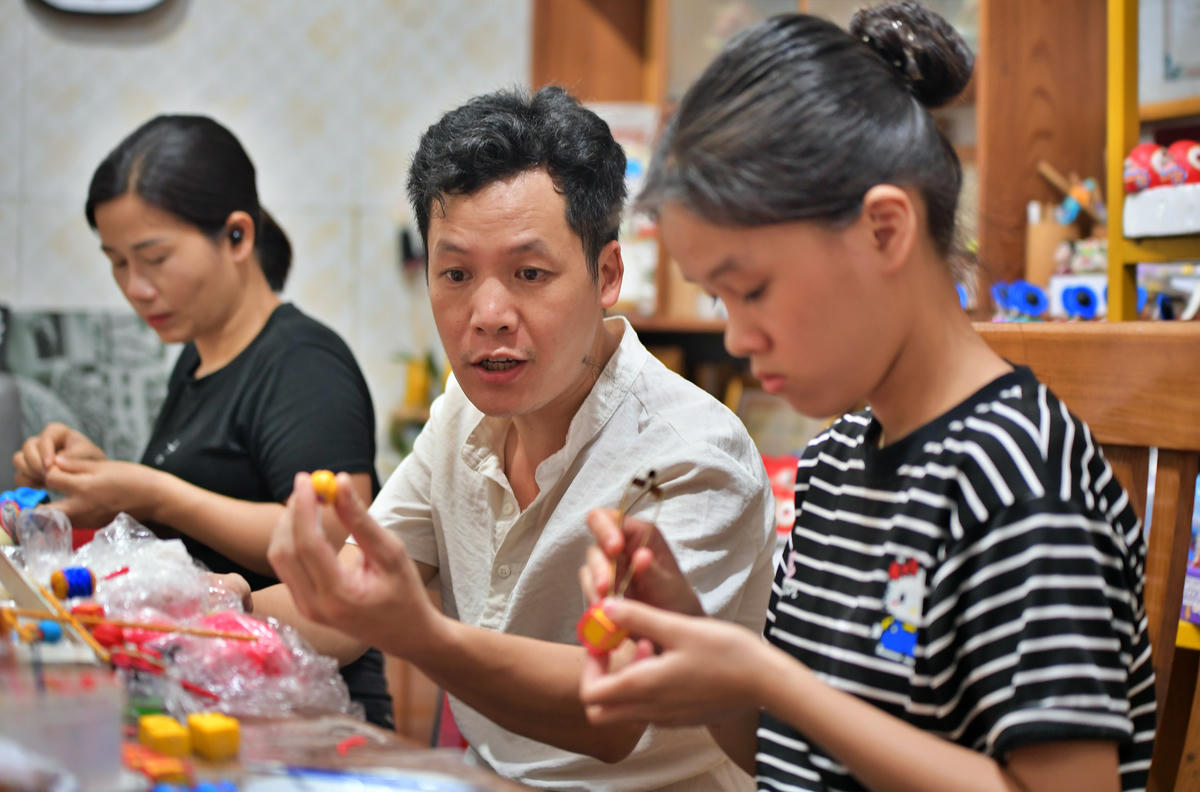 Nghệ nhân Đặng Văn Hậu hướng dẫn các em nhỏ thực hành nặn tò he.