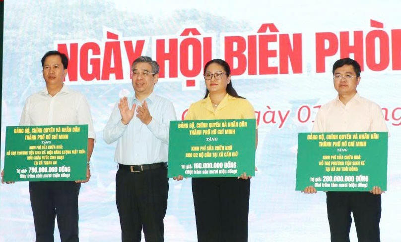 Lãnh đạo TP Hồ Chí Minh trao bảng tượng trưng kinh phí xây dựng, sửa chữa nhà Đại đoàn kết trong chương trình “Ngày hội Biên phòng toàn dân” tại xã Cần Giờ. Ảnh: MTTP.