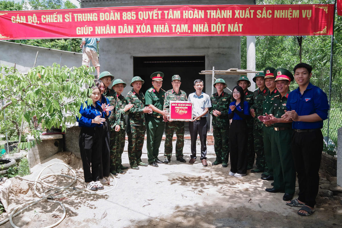 Lãnh đạo Bộ CHQS TP Đà Nẵng tặng quà cho gia đình được hỗ trợ xóa nhà tạm, nhà dột nát trong chương trình tại xã Quế Sơn. Ảnh: QC.