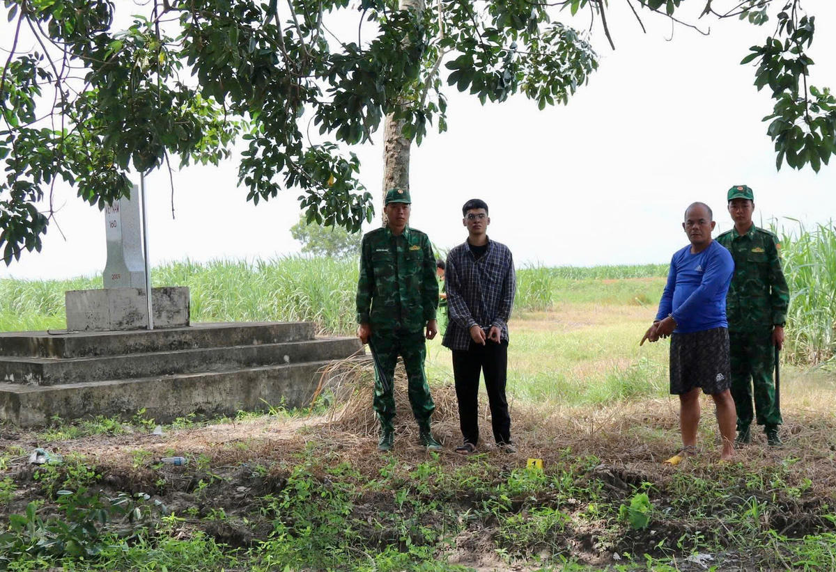 Đối tượng Phạm Tiến Nghĩa (áo xanh) bị bắt quả tang khi đang tổ chức đưa Nguyễn Trung Kiên nhập cảnh trái phép từ Campuchia vào Việt Nam. Ảnh: H.B.