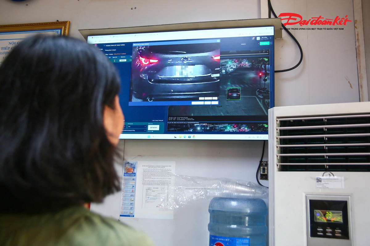 Người phụ nữ xem lại hình ảnh vi phạm được hệ thống camera ghi nhận trước khi thực hiện thủ tục xử lý.