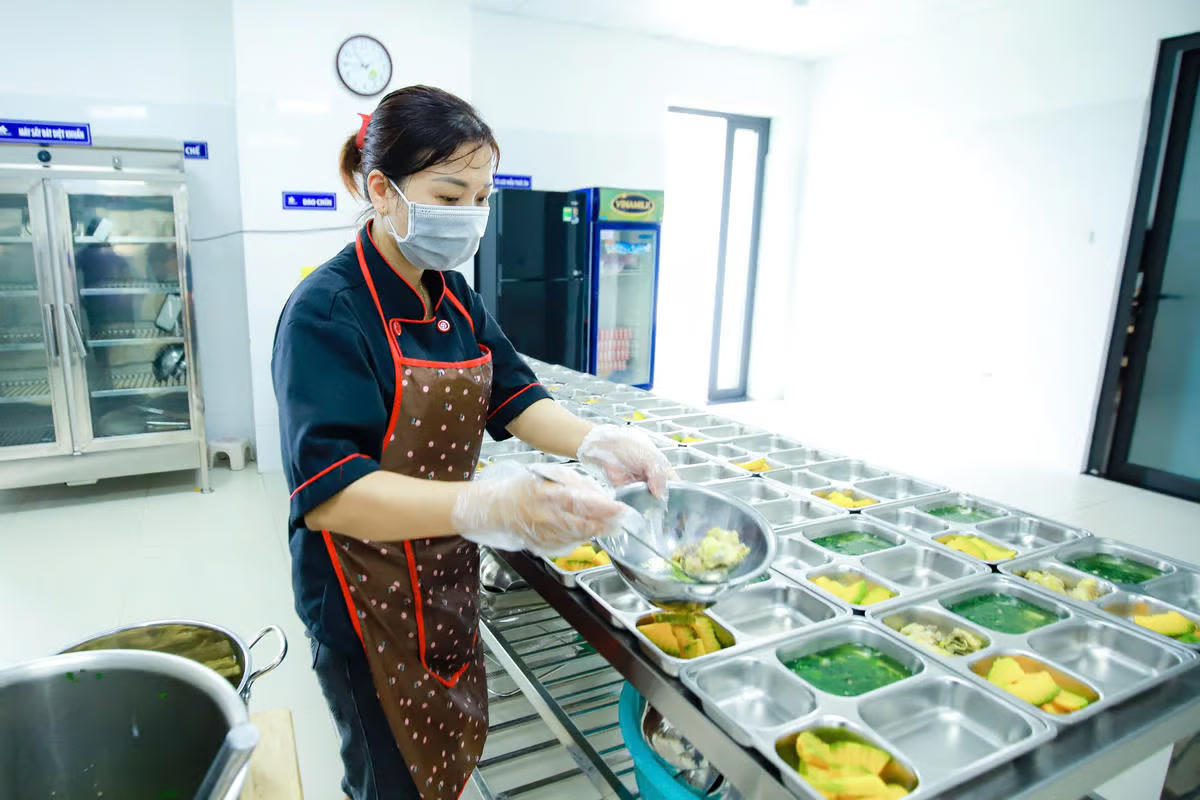  Chuẩn bị bữa ăn bán trú cho các em học sinh tại một trường học ở Hà Nội. Ảnh: Quang Vinh