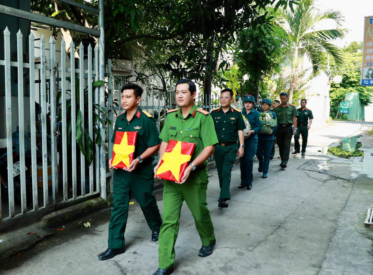 Các cán bộ, chiến sĩ bộ đội và công an nhân dân đến tận nhà thân nhân liệt sĩ để trao di ảnh. Ảnh: Bộ Tư lệnh TPHCM cung cấp.