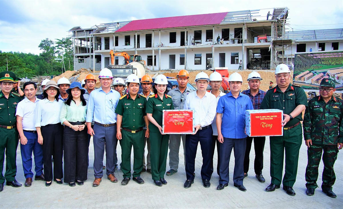 Chủ tịch UBND TP Đà Nẵng Nguyễn Mạnh Hùng (áo trắng) tặng quà cho công nhân đang thi công tại Trường Phổ thông nội trú liên cấp La Dêê. Ảnh: Mai Quang.