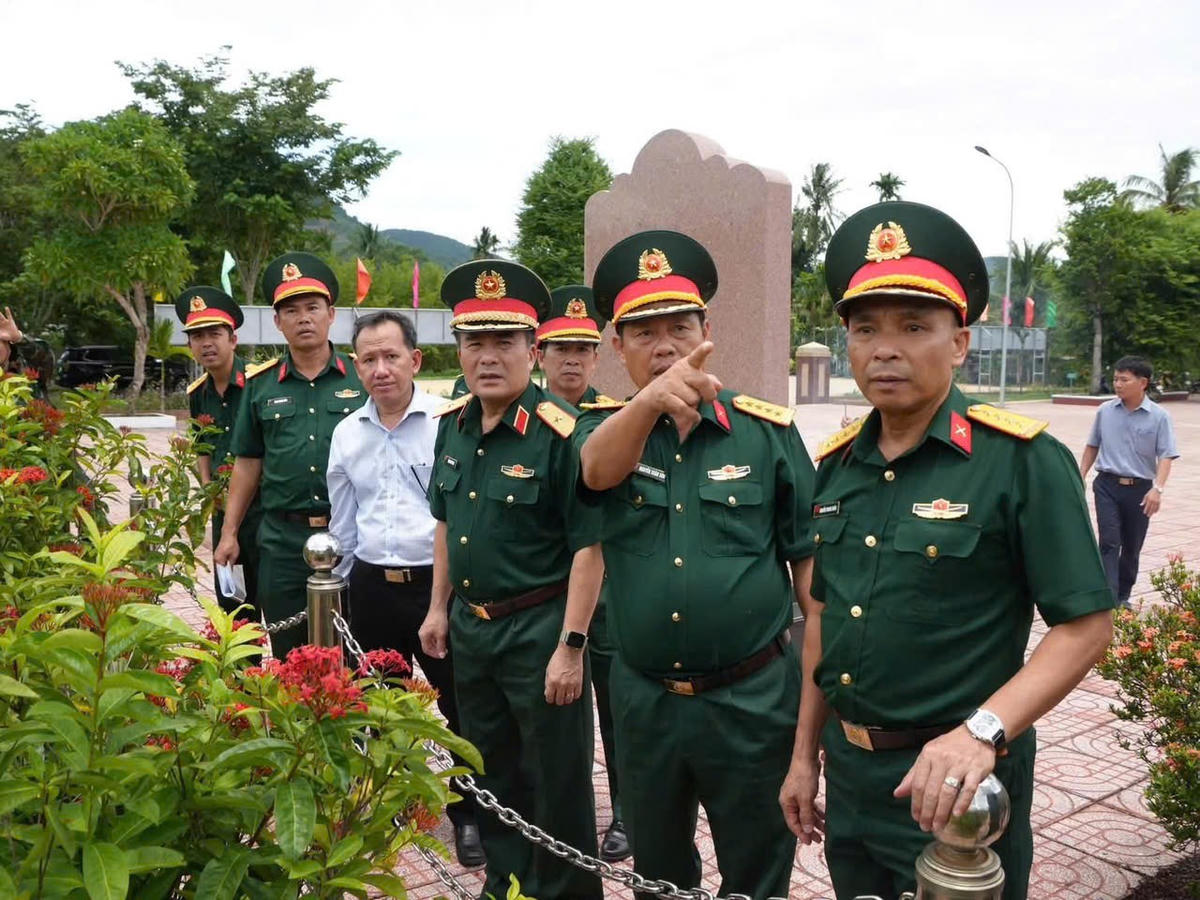 Thiếu tướng Trần Minh Trọng, Phó Chính ủy Quân khu 5 khảo sát, tìm kiếm, quy tập hài cốt liệt sĩ tại khu vực Đồi Xuân Sơn (ông đeo đồng hồ đứng gần áo trắng). Ảnh: ĐS.