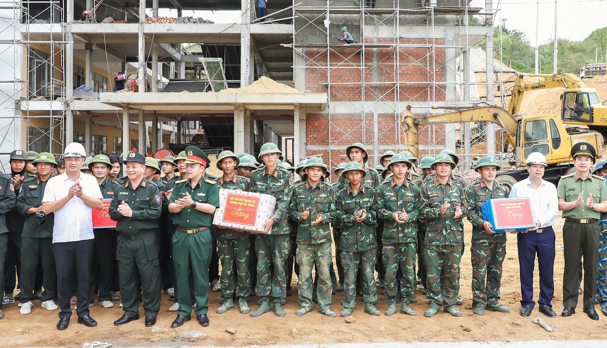 Bí thư Thành ủy Đà Nẵng Lê Ngọc Quang (bên trái, áo trắng) tặng quà cho lực lượng thi công Trường Phổ thông nội trú Tiểu học và Trung học cơ sở Đắc Pring. Ảnh: MQ.