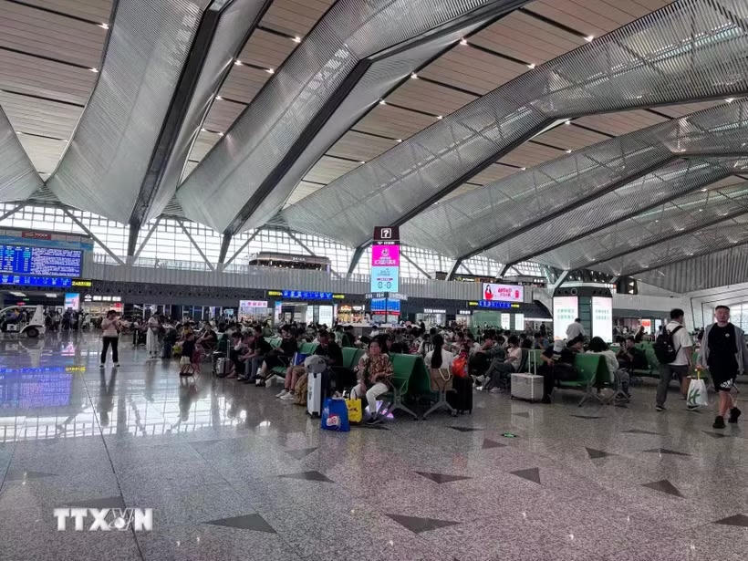 Hành khách chờ tàu tại một nhà ga ở Trung Quốc.	Ảnh: TTXVN.