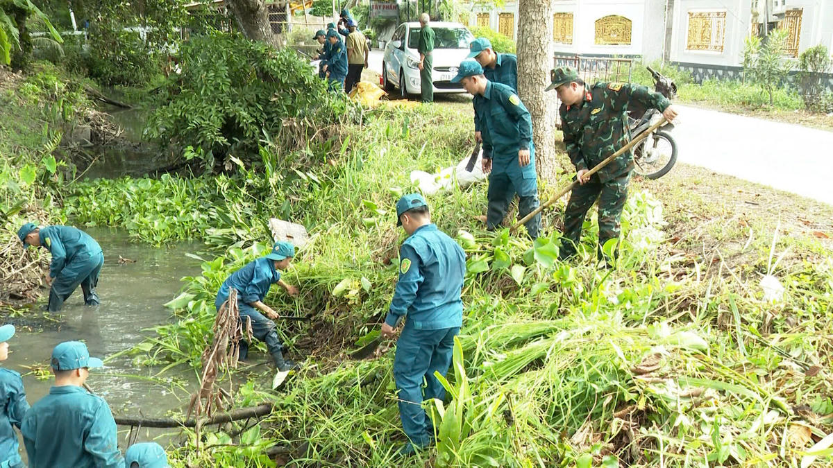 Cán bộ, đoàn viên Bộ đội Biên phòng cùng lực lượng địa phương nạo vét, khơi thông tuyến kênh, góp phần làm sạch môi trường. (Ảnh: Trần Giỏi).