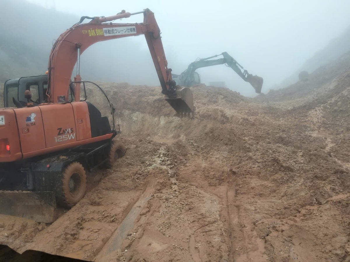 Máy móc khắc phục điểm sạt lở đất đá trên tuyến đường xã Kon Đào. Ảnh: NP.