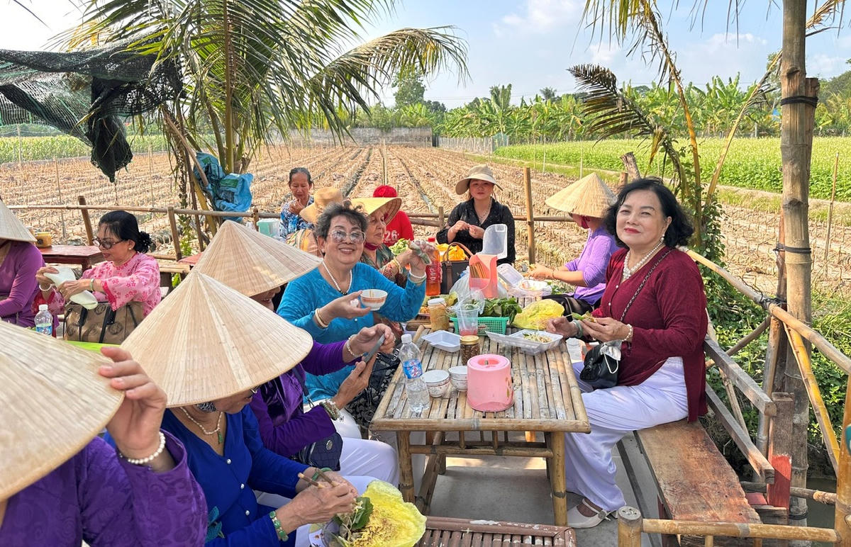 Du khách thưởng thức bánh xèo tại chợ phiên Xóm Rẫy, phường Mỹ Ngãi, tỉnh Đồng Tháp. (Ảnh: Thanh Lâm).