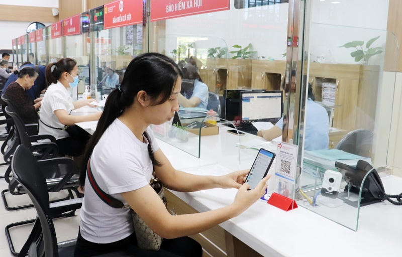 Người dân quét mã QR để thực hiện phiếu khảo sát đánh giá sự hài lòng trong giải quyết công việc. Ảnh: QMG. 