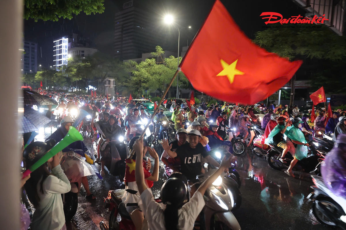 Những lá cờ đỏ sao vàng tung bay trong mưa, tiếng kèn và tiếng reo hò vang lên trên nhiều tuyến phố, tạo nên một đêm ăn mừng đầy cảm xúc của người hâm mộ Thủ đô.