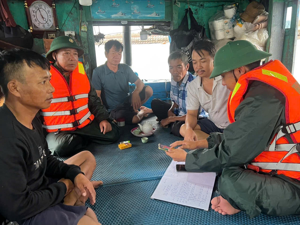 Cán bộ BĐBP thành phố Hải Phòng thông tin về áp thấp nhiệt đới cho bà con ngư dân. Ảnh: NK.