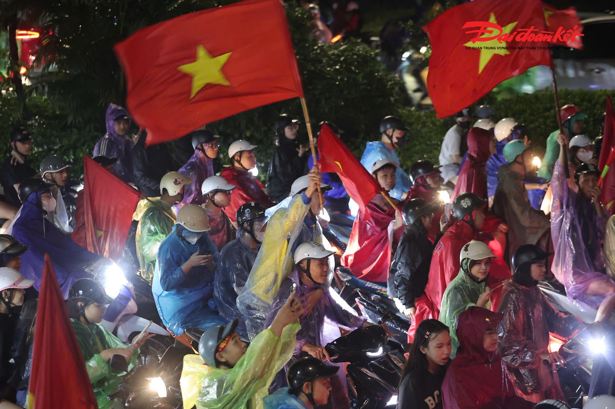 Dù mưa lớn kéo dài, dòng người vẫn đổ về các tuyến đường trung tâm. Nhiều cổ động viên khoác trên mình quốc kỳ, vừa di chuyển vừa hô vang những khẩu hiệu cổ vũ đội tuyển Việt Nam.