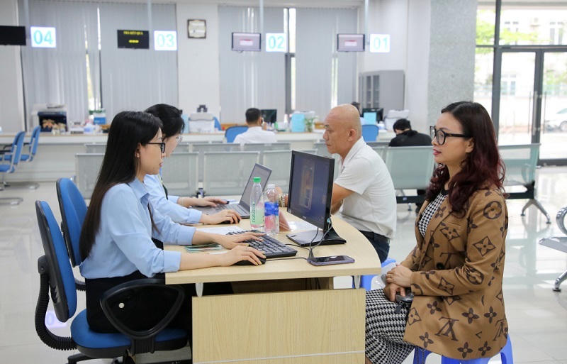 Cán bộ Trung tâm Phục vụ hành chính công tỉnh Quảng Ninh hỗ trợ người dân nộp hồ sơ dịch vụ công trực tuyến. Ảnh: QMG. 