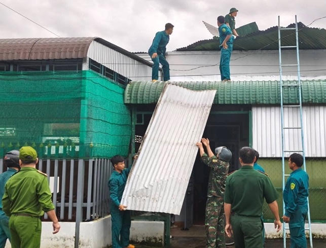 Cán bộ, chiến sĩ Ban CHQS xã Đạ Tẻh 2, hỗ trợ người dân khắc phục nhà bị tốc mái do dông lốc.