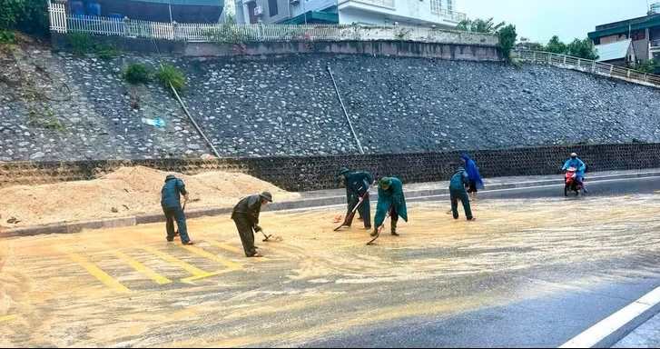 Lực lượng chức năng phường Hồng Gai xúc dọn đất đá, dọn dẹp mặt đường, tạo điều kiện để các phương tiện lưu thông an toàn. Ảnh: QMG. 