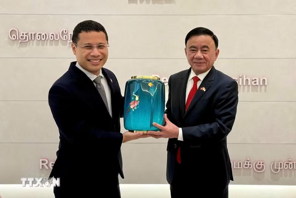 Ủy viên Bộ Chính trị, Thường trực Ban Bí thư Trần Cẩm Tú và Chủ tịch Đảng Hành động Nhân dân Singapore Desmond Lee trao tặng phẩm. (Ảnh: Phương Hoa/TTXVN)