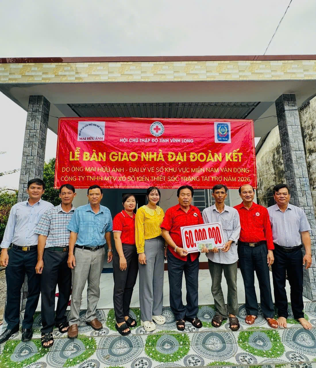 Đại lý vé số Mai Hữu Ánh trao biển tượng trưng hỗ trợ 60 triệu đồng tại lễ bàn giao nhà Đại đoàn kết ở Vĩnh Long. (Ảnh: Anh Hoàng).