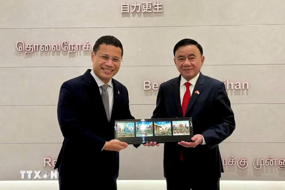 Ủy viên Bộ Chính trị, Thường trực Ban Bí thư Trần Cẩm Tú và Chủ tịch Đảng Hành động Nhân dân Singapore Desmond Lee trao tặng phẩm. (Ảnh: Phương Hoa/TTXVN)