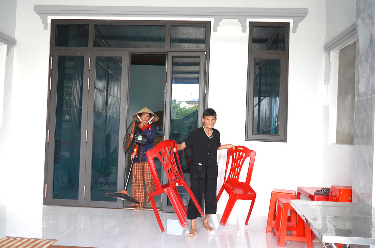 Bà Trần Thị Hạnh - vợ của thương binh Lê Bá Hữu tất bật sửa soạn đồ đạc đưa lên nhà mới, ngôi nhà nghĩa tình. Ảnh: HN.