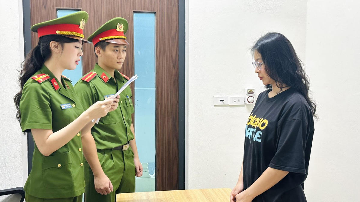 Lê Thị Thanh Hằng nghe Công an đọc lệnh khởi tố. Ảnh: CATH