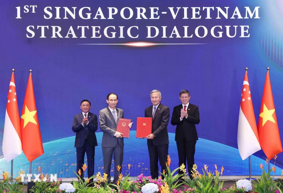 Uỷ viên Bộ Chính trị, Bộ trưởng Ngoại giao Lê Hoài Trung và Bộ trưởng Ngoại giao Singapore Vivian Balakrishnan trao Bản ghi nhớ hợp tác giữa hai Đảng. (Ảnh: Phương Hoa/TTXVN)