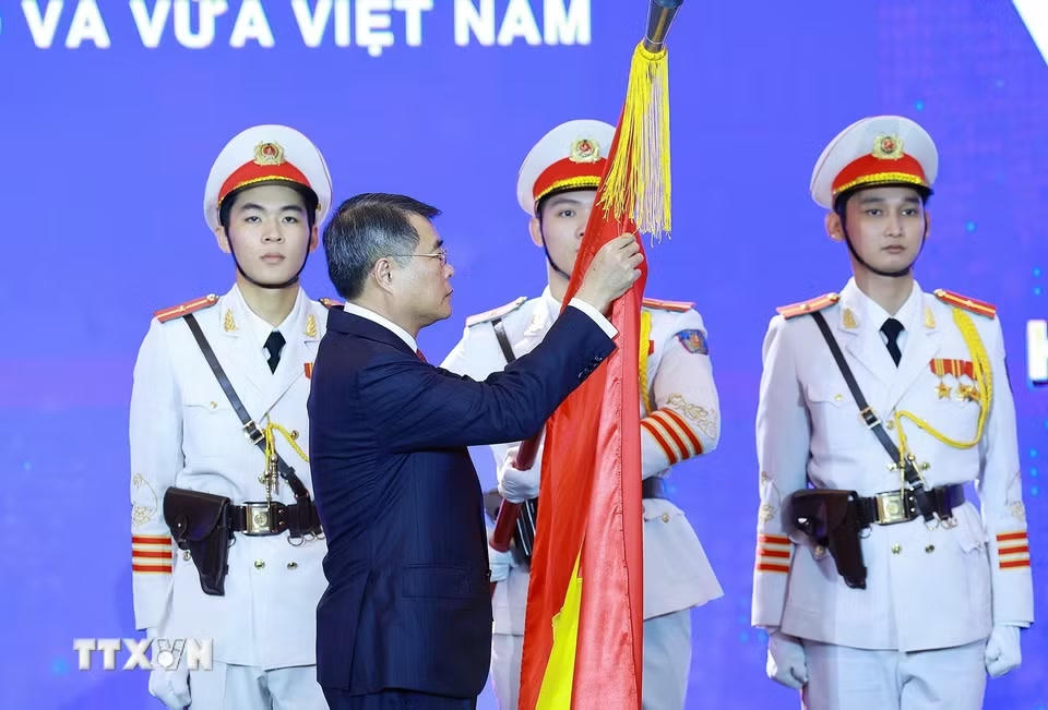 Thủ tướng Lê Minh Hưng gắn Huân chương Lao động hạng Nhất lên Cờ truyền thống của Hiệp hội Doanh nghiệp nhỏ và vừa Việt Nam. (Ảnh: Dương Giang/TTXVN)