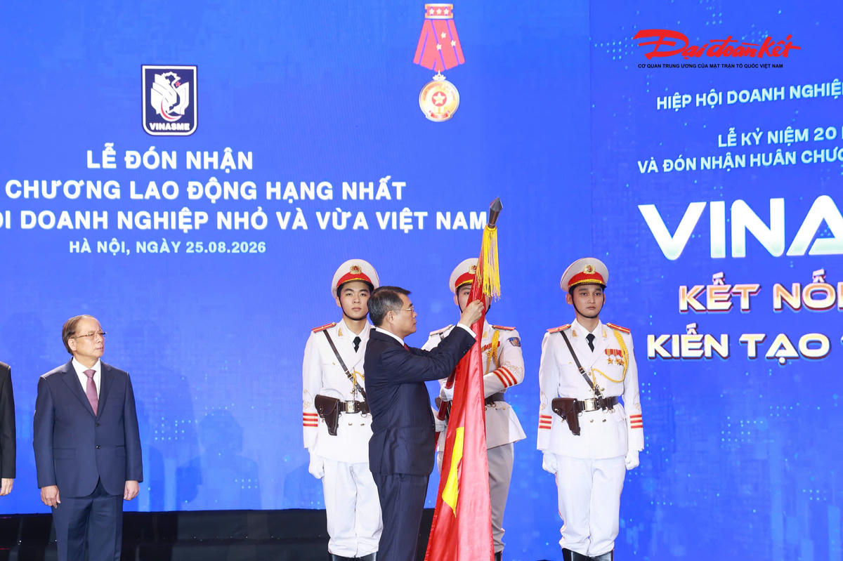Thủ tướng Chính phủ Lê Minh Hưng gắn Huân chương Lao động hạng Nhất lên Cờ truyền thống của Hiệp hội Doanh nghiệp nhỏ và vừa Việt Nam. (Ảnh: Quang Vinh)