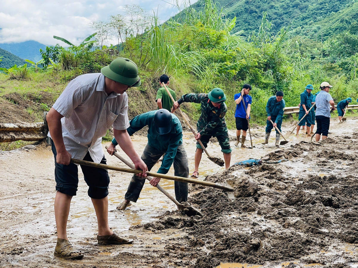 Ông Lù Quy Nhân - Phó Chủ tịch UBND xã Pù Nhi cùng lực lượng chức năng dọn dẹp đất đá sạt lở xuống đường ngày 25/8. Ảnh: DVC Pù Nhi.