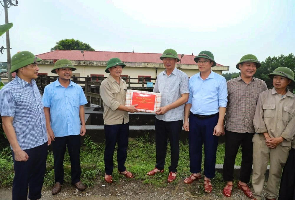 Ông Sinh tặng quà cán bộ, nhân viên Chi nhánh thủy lợi Thạch Thành. Ảnh: Đỗ Đức