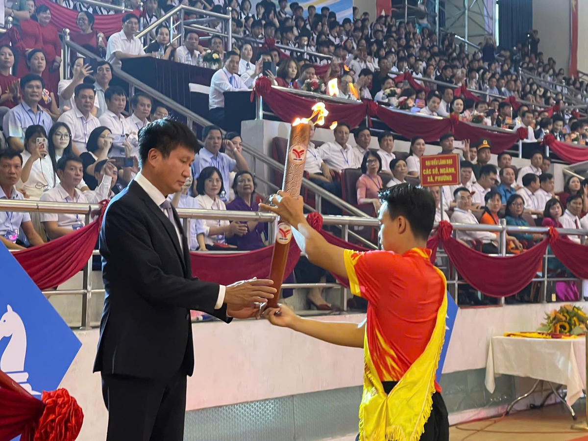 Bí thư Tỉnh ủy Trần Huy Tuấn tiếp nhận và thực hiện nghi thức thắp sáng đài lửa đại hội. Ảnh: Đình Minh