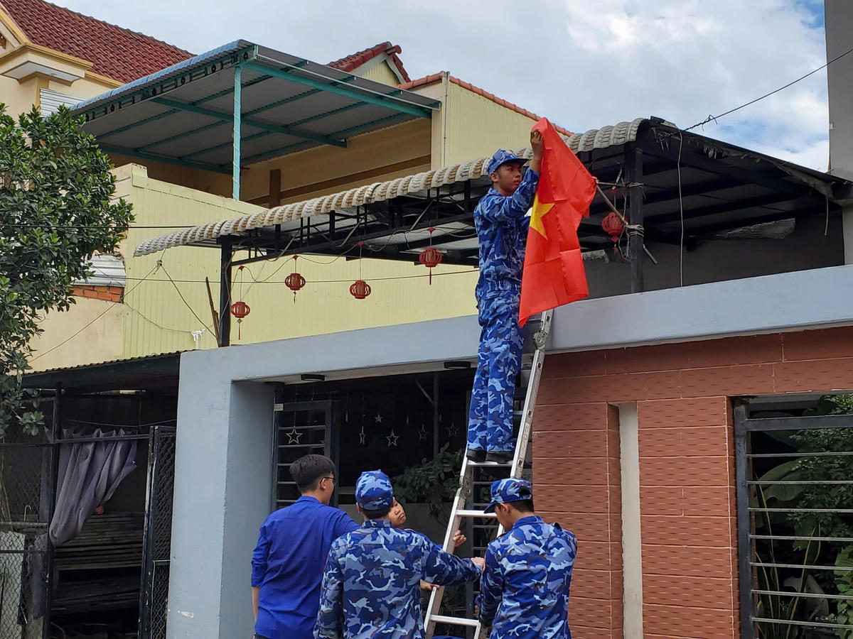 Chiến sĩ Hải đoàn 21 giúp người dân treo cờ Tổ quốc. Ảnh: CS.