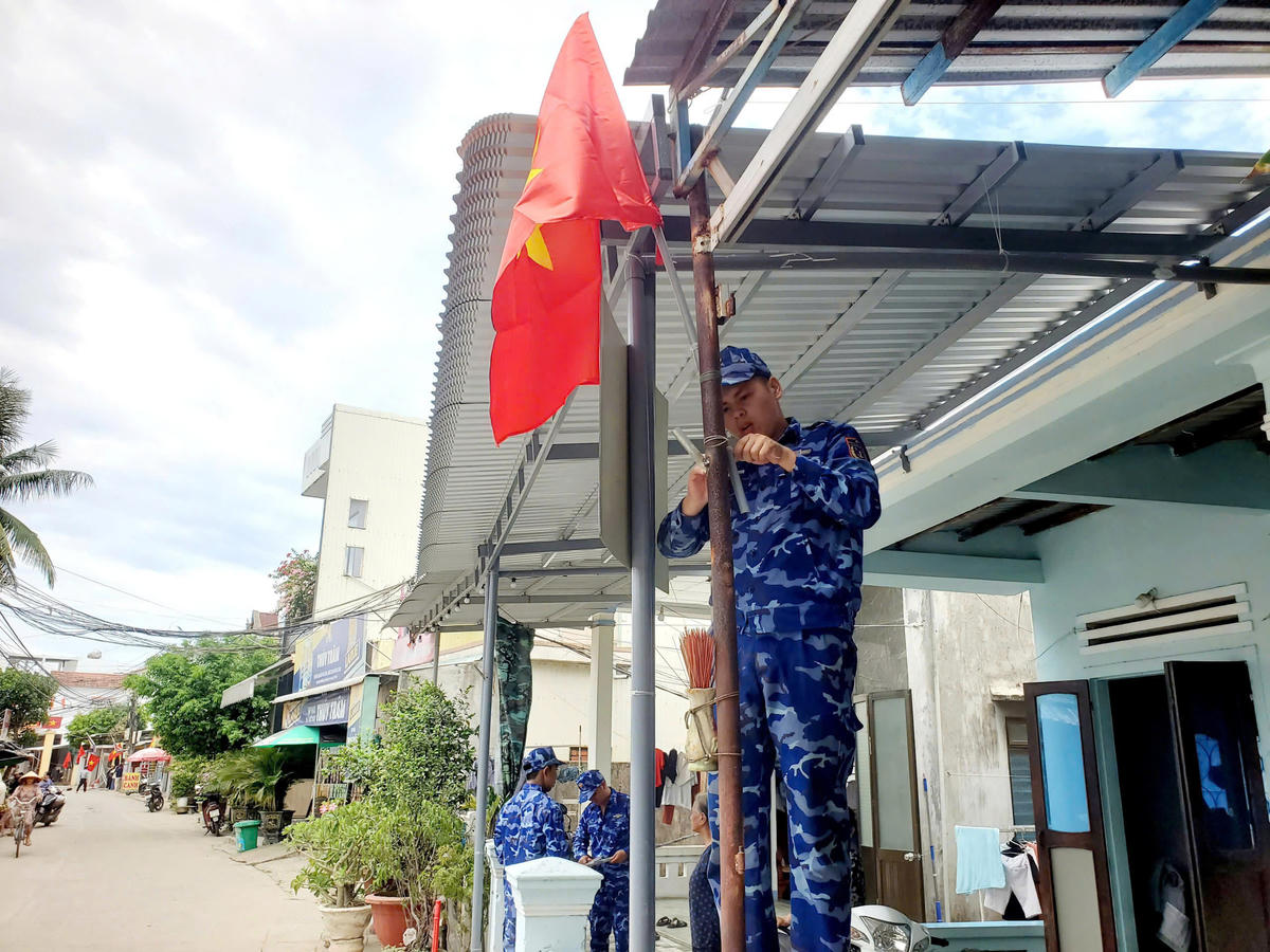 Những lá cờ Tổ quốc được chiến sĩ Hải đoàn 21 treo trước hiên nhà dân trang trọng. Ảnh: CS.