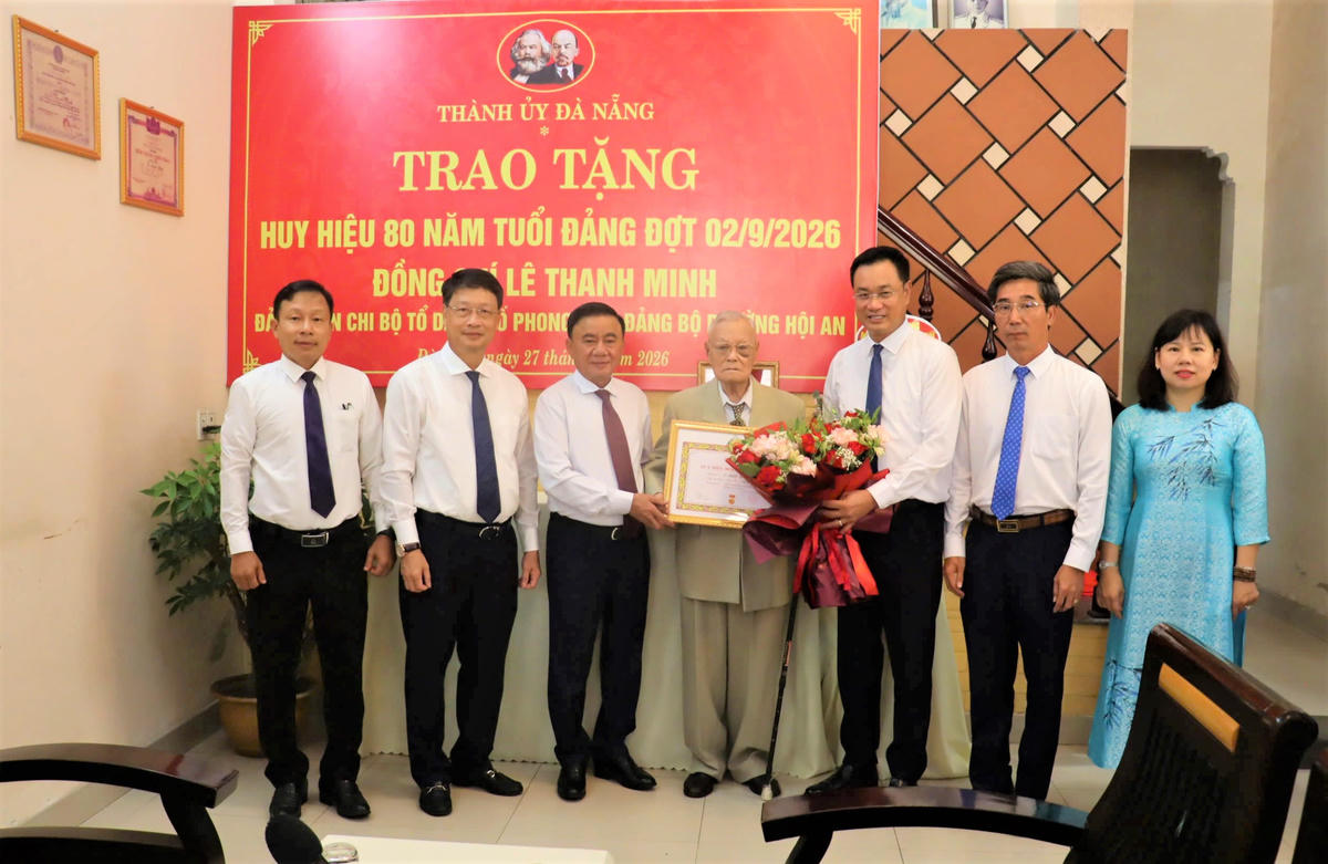Thường trực Ban Bí thư Trần Cẩm Tú (bên phải) trao Huy hiệu 80 năm tuổi Đảng, tặng hoa chúc mừng đảng viên Lê Thanh Minh. Ảnh: TT.