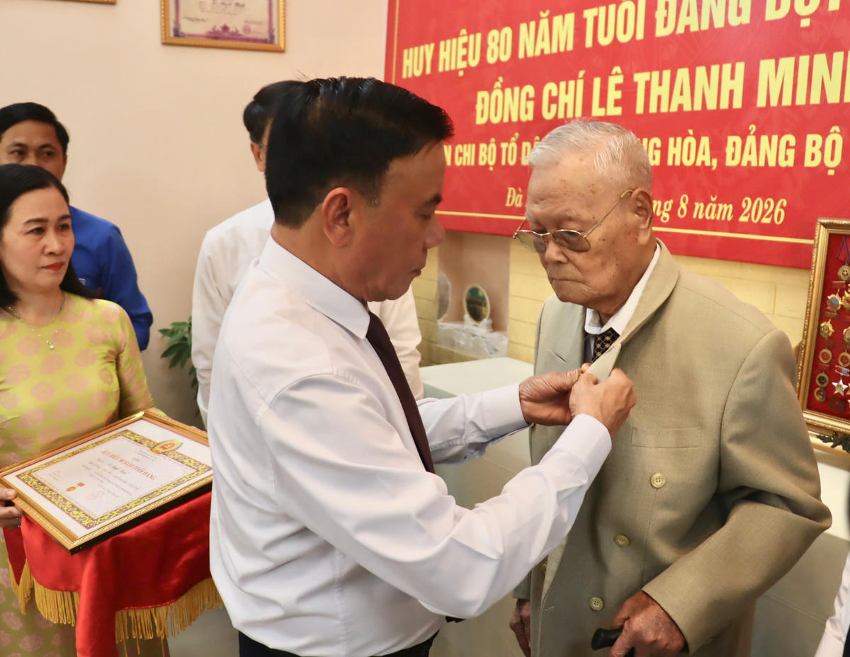 Thường trực Ban Bí thư Trần Cẩm Tú gắn Huy hiệu 80 năm tuổi Đảng cho đảng viên lão thành Lê Thanh Minh. Ảnh: CĐ.